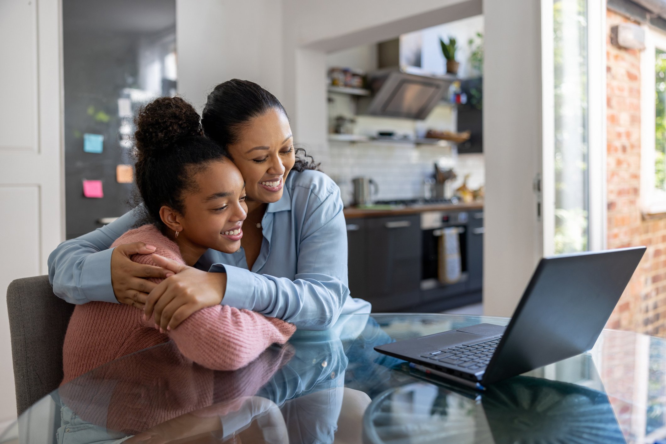 Loving mother and daughter getting good news online